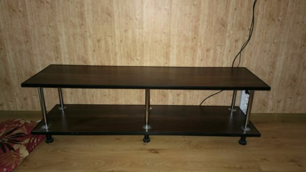 TV table. Material - laminated board, glued in two layers, substrate to substrate. Racks are made of chrome steel pipe edging - U-shaped plastic profile.
