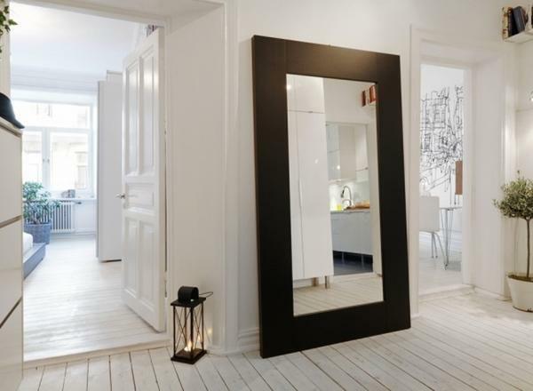 Spegel i en vacker ram betonar vackra hall designen